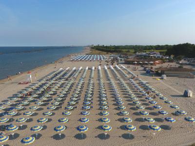 Beach with yellow and blue umbrellas, calm sea.
