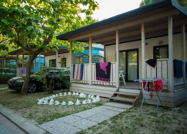 Bungalow con asciugamani appesi e auto parcheggiata.